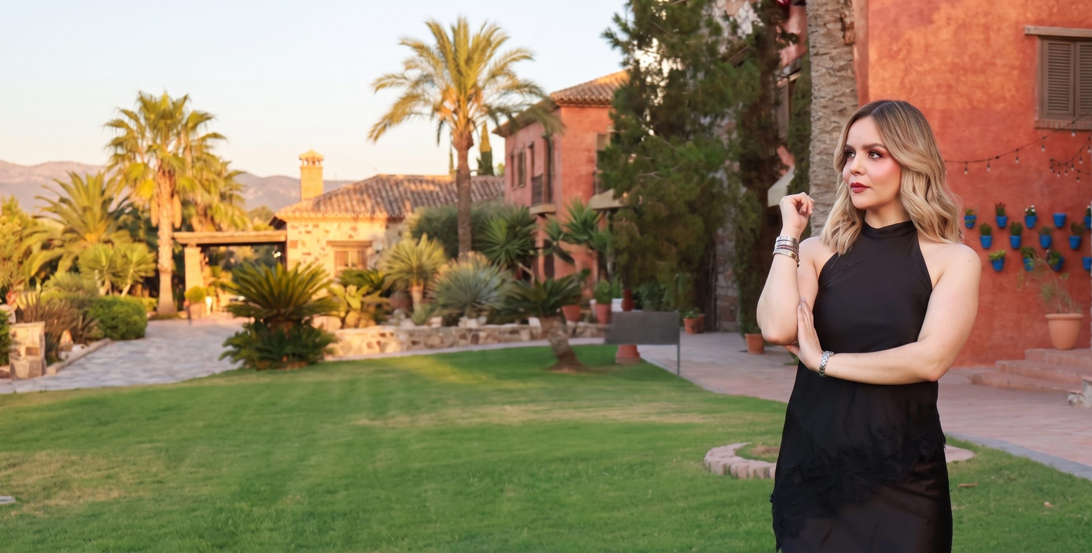 Gladys Morán en el jardín de una villa al atardecer